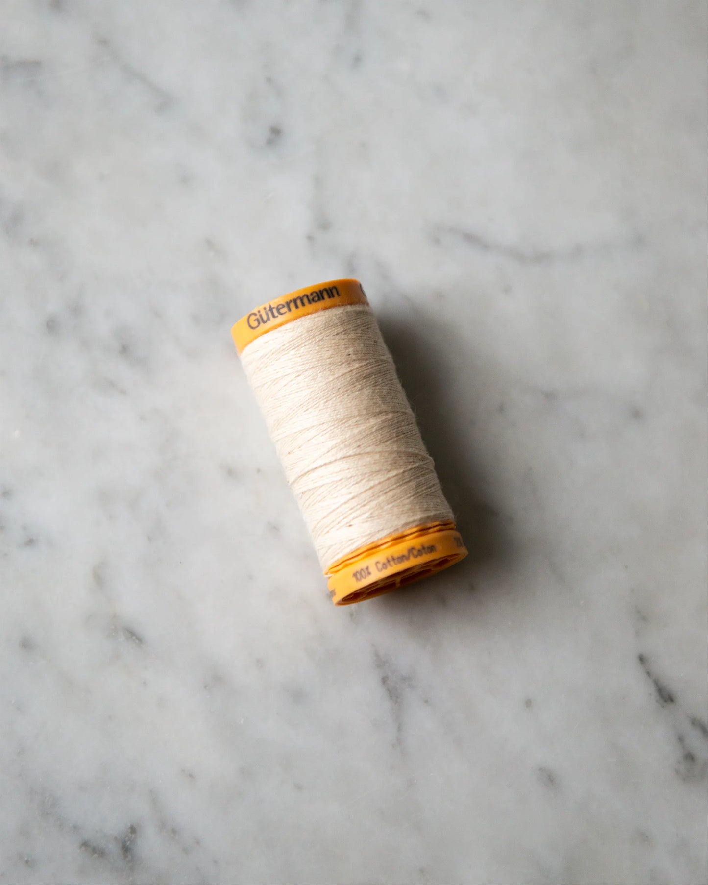 En naturfärgad tråckeltråd på rulle.