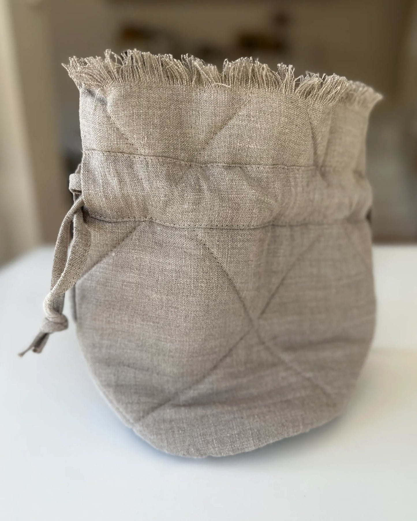 En handsydd quiltad påsväska med fransar i linne.