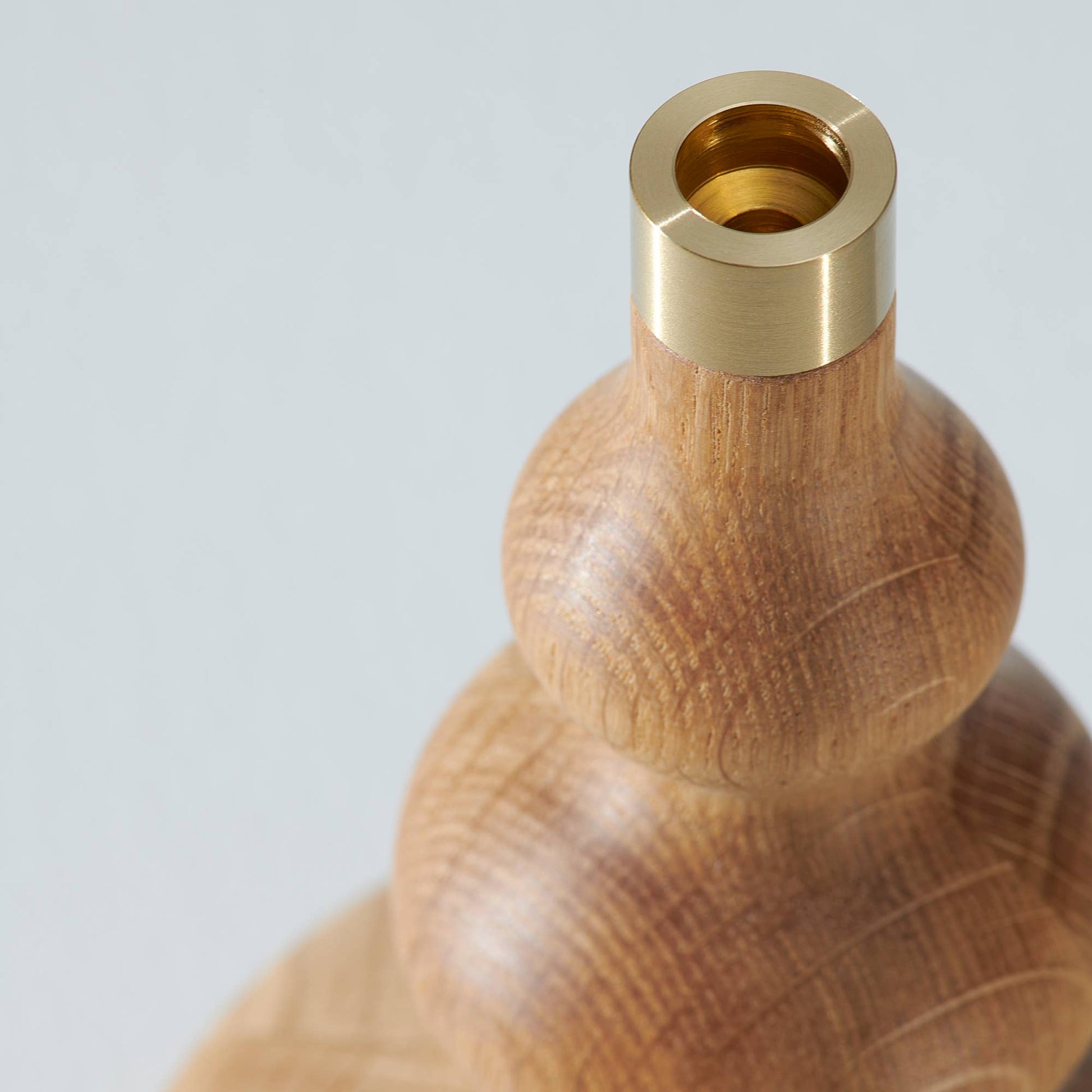 Ett mässingskaft på en ljusstake i trä 