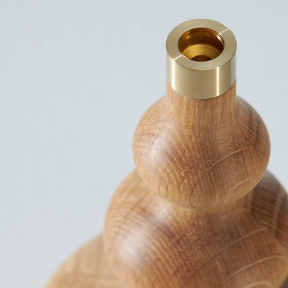 Ett mässingskaft på en ljusstake i trä 