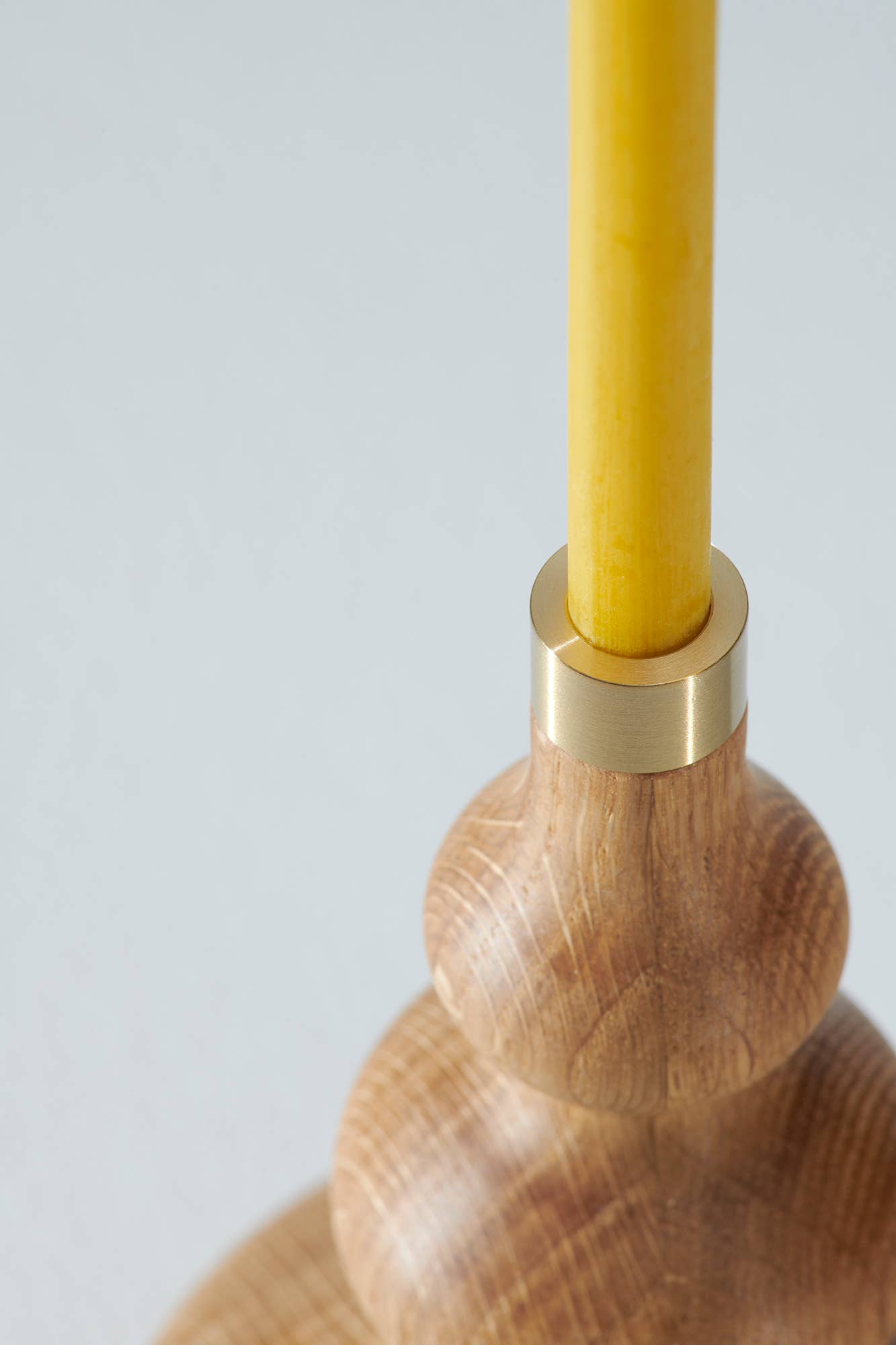 Ett smalt bivaxljus i en träljusstake