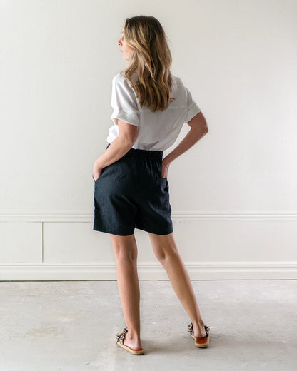 Svarta linneshorts och vit kortärmad linneblus 