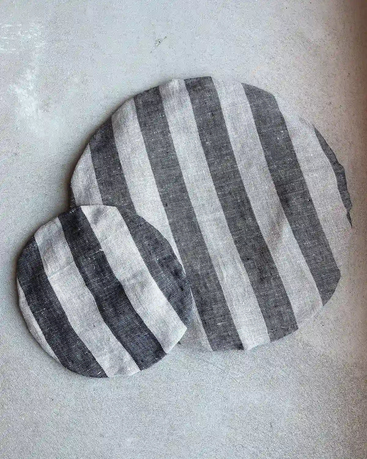 Två skålöverdrag i svart och beige 