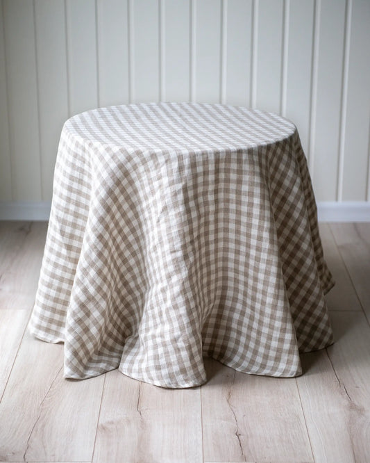 En handsydd rund duk i rutigt mönster i beige och vit.